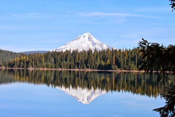 A mountain mirrored in the glassy surface of a still alpine lake.
